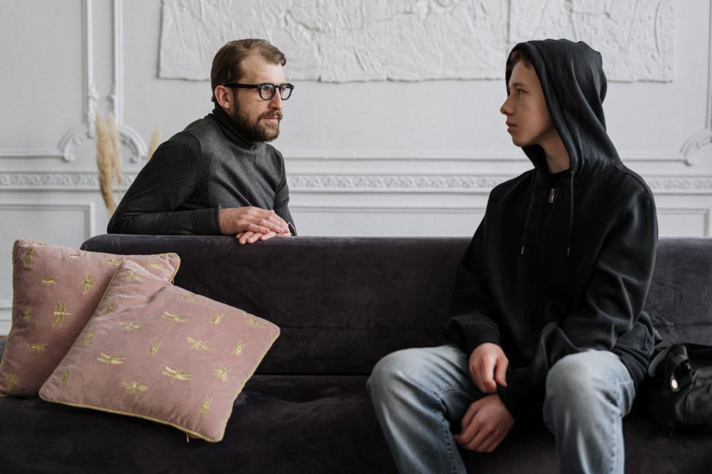 Man and teenager talking in therapy